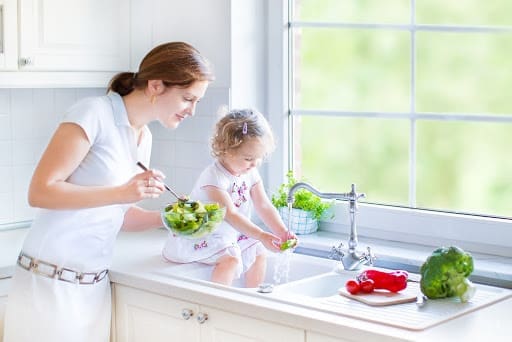 Mom and daughter washing vegetables