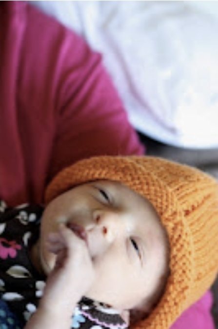 Baby in an orange knit hat