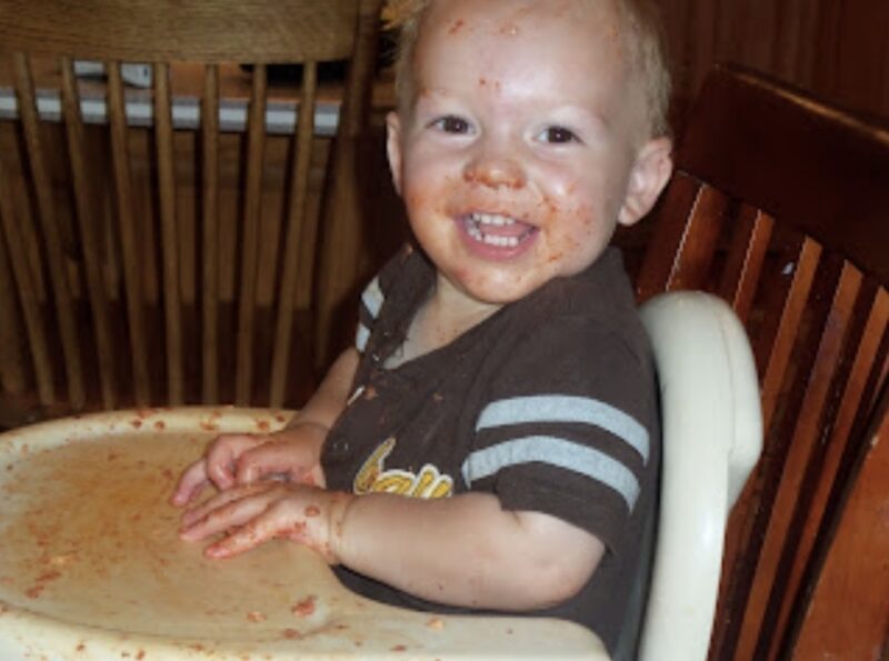 Little boy covered in spaghetti sauce 