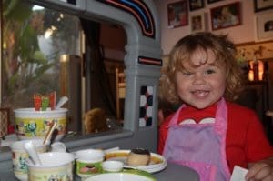 Smiling little girl playing with play dishes