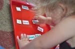 Little girl placing words on tray