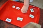 Little hands placing words on tray