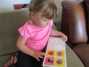 Little girl reading Hey Baby Look! By Kate Shannon