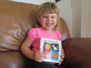 Little girl reading Hey Baby Look! By Kate Shannon