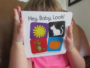 Little girl reading Hey Baby Look! By Kate Shannon