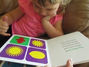 Little girl reading Hey Baby Look! By Kate Shannon