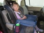 Little girl in car seat with snack play tray
