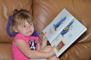 Little girl with dinosaur book