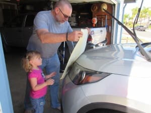 Grandpa and granddaughter cleaning car