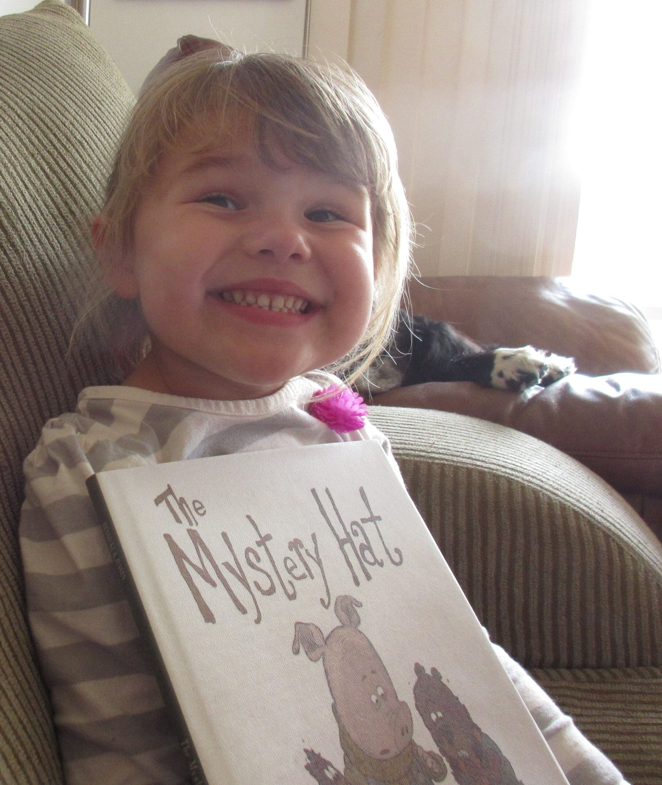The Mystery Hat Book and a smiling little girl