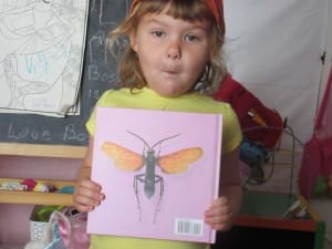 Little girl reading The Alphabet Of Bugs An ABC Book