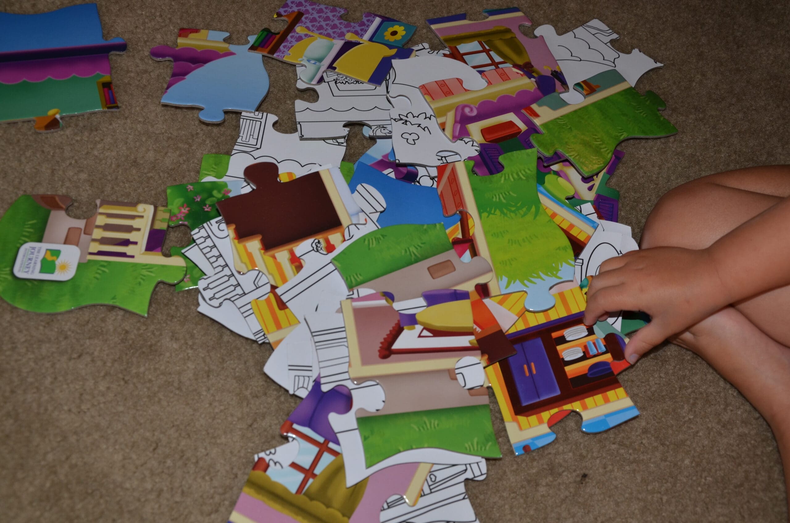 Little girl putting together a dollhouse puzzle for kids