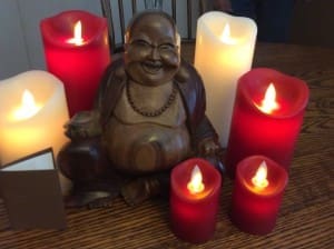 Laughing Budda statue with candles