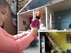 Little girl playing with Doll house