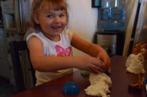 little girl playing with floof sands alive