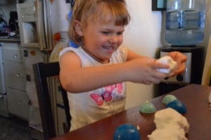 little girl playing with floof sands alive