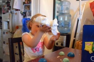 little girl playing with floof sands alive