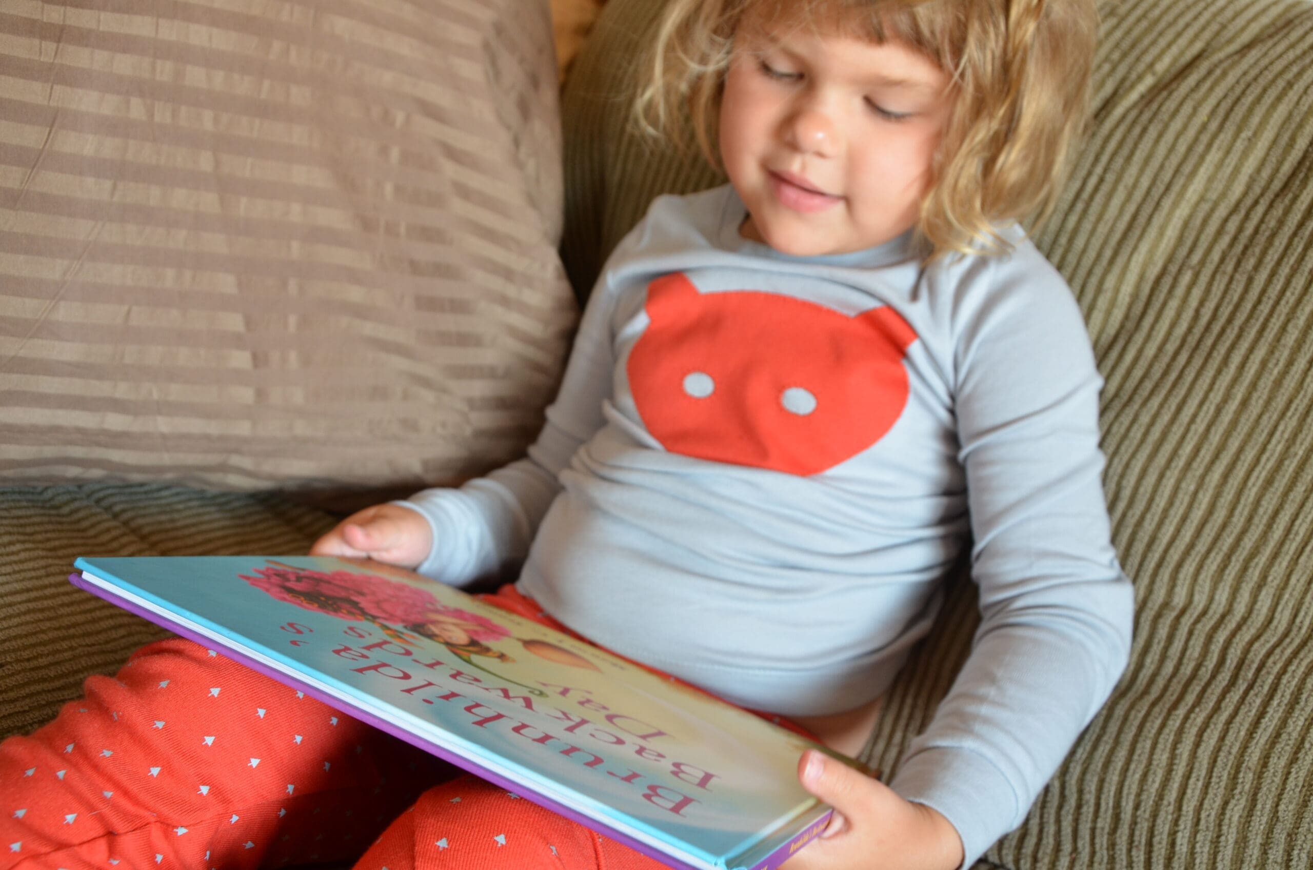 Little girl reading Brunhilda's Backwards Day book