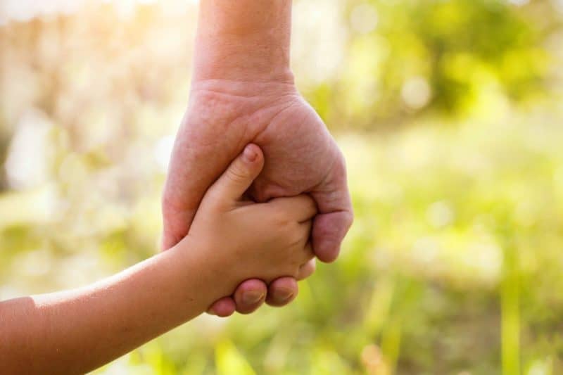 Child and parent holding hands