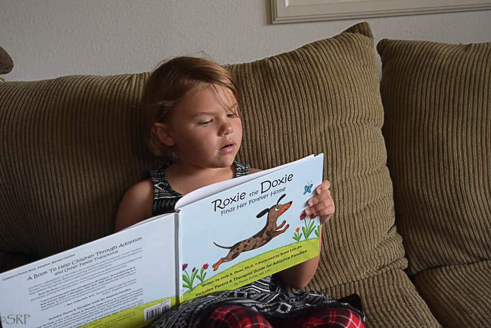 Cute little girl reading Roxie the Doxie book