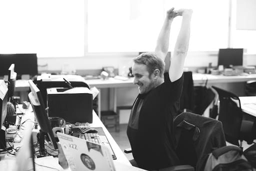 Starting A Business Man at computer stretching