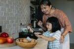 Woman and child help in the kitchen cooking 