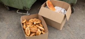Bakery boxes with leftover food and baked goods to be thrown away in the nearby dumpsters.