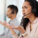 A woman with an exasperated expression gesturing with two open palms to her monitor. She is wearing a headset. Tax Professionals