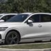 A new Genesis GV70 Sport stock turbocharged SUV is parked in a dealership lot surrounded by similar vehicles.