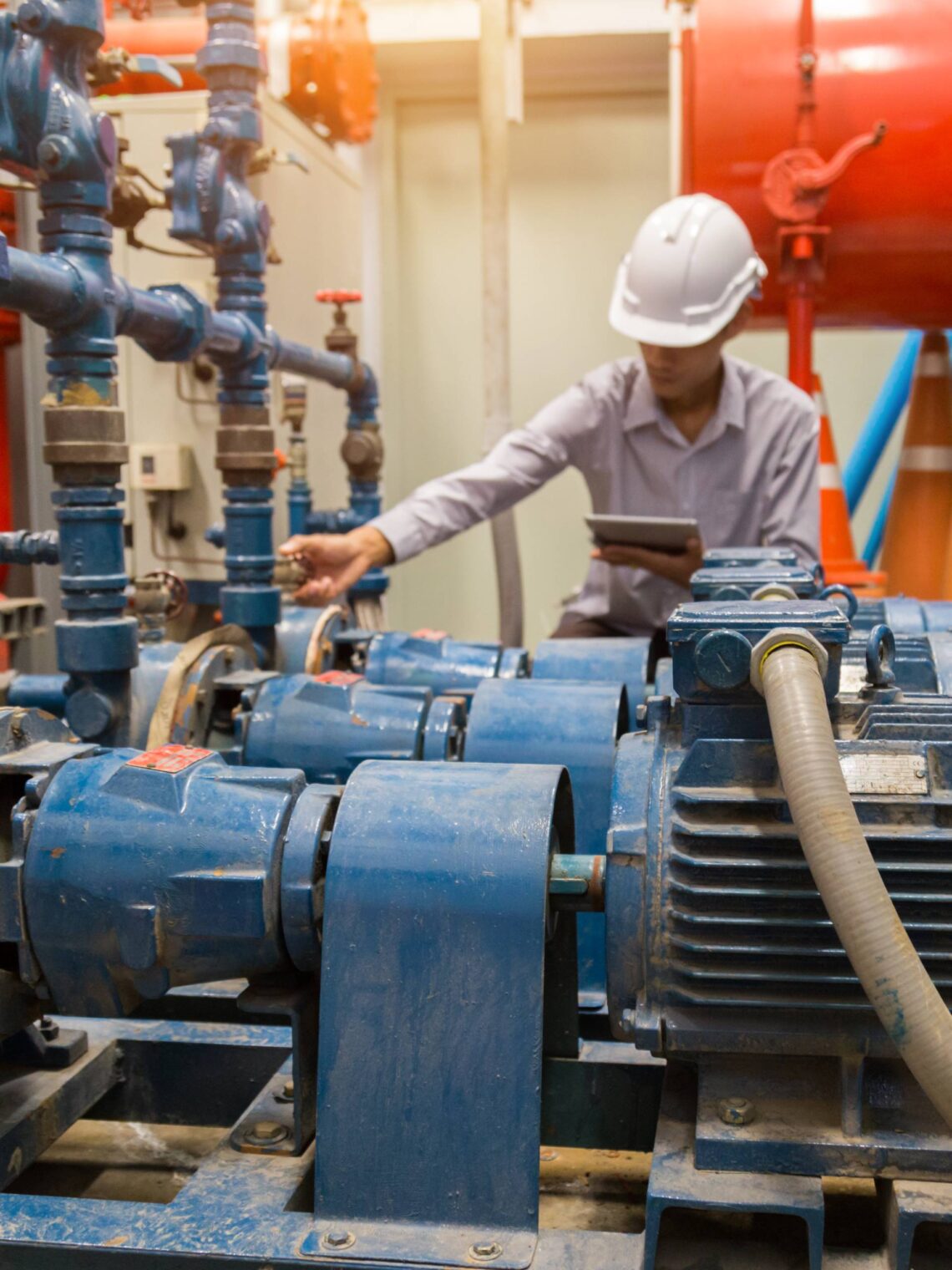 An operational technician working behind the scenes in a warehouse, servicing the industrial electric motors.