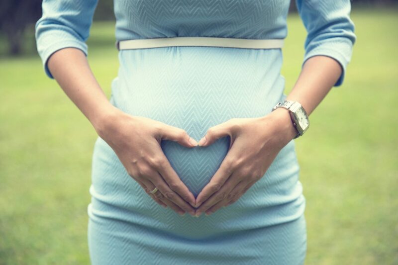 Pregnant woman with hands on her belly