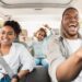 A family of three enjoying a car ride. The parents are in the front seat, and the daughter is in the back seat singing.