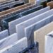 Rows of square natural stone samples in a range of colors showing different variations and patterns.