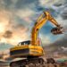 A yellow crawler excavator on dirt tracks lifts a bucket of soil above an earthwork area under a cloudy sunset sky.