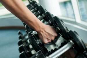 a shot of someone choosing a weight. to work out with for a healthier lifestyle