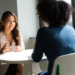2 women sitting at a table.Difficult Conversations