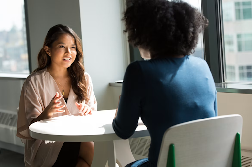 2 women sitting at a table.Difficult Conversations
